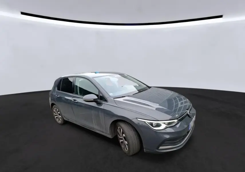 Volkswagen Golf 1.5 eTSI gris vue 3/4 avant droit avec phares LED allumés sur fond neutre.