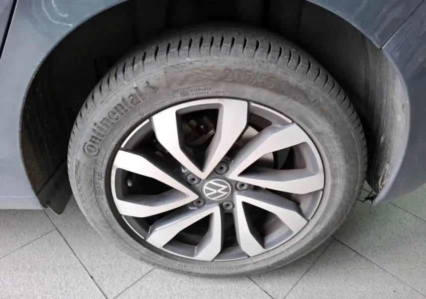 Gros plan sur la roue avant gauche d'une Volkswagen Golf gris 2022 avec jante alliage et pneu Continental.