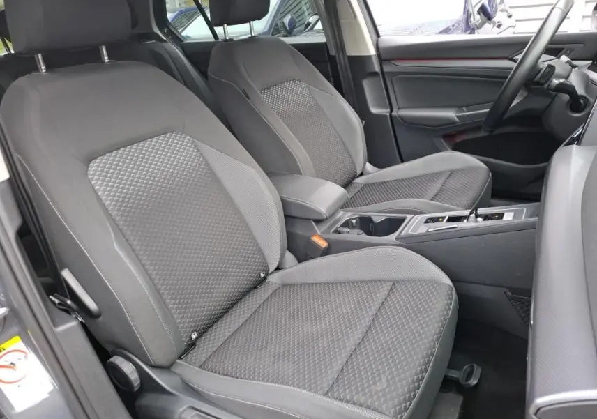 Vue intérieure côté conducteur de la Volkswagen Golf 1.5 eTSI 130 DSG7 Active 2022 avec sièges tissu gris et console centrale.