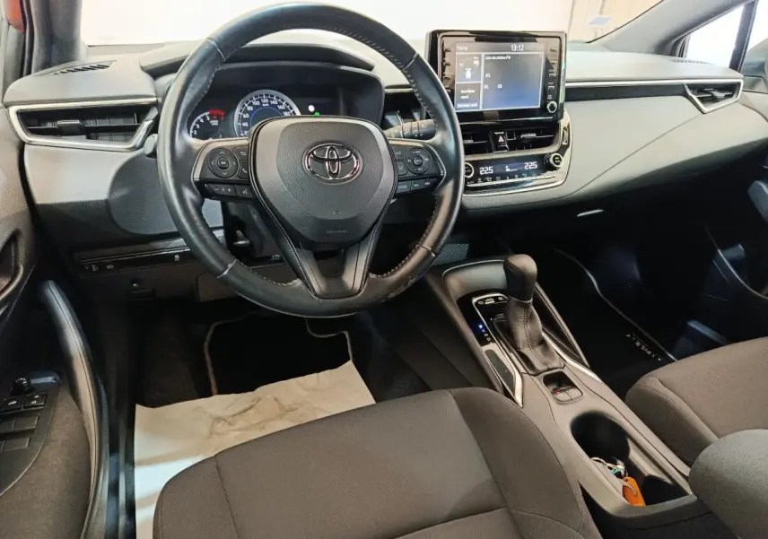 Vue intérieure avant de la Toyota Corolla Hybride 122h Active 2020, volant cuir multifonctions et écran tactile central.