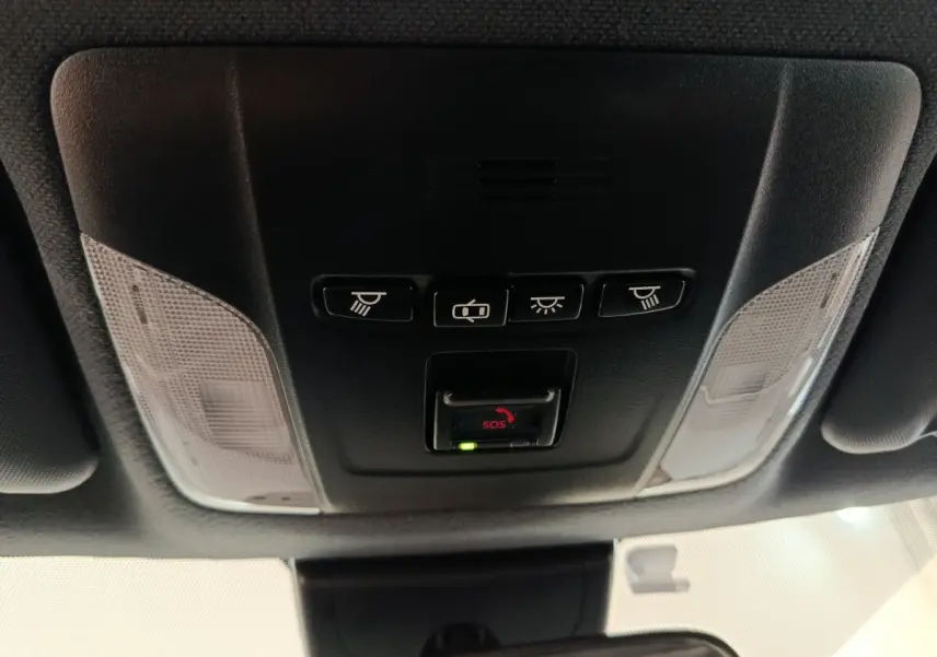 Vue en contre-plongée du plafonnier noir avec commandes d’éclairage et bouton SOS de la Toyota Corolla Hybride 2020.