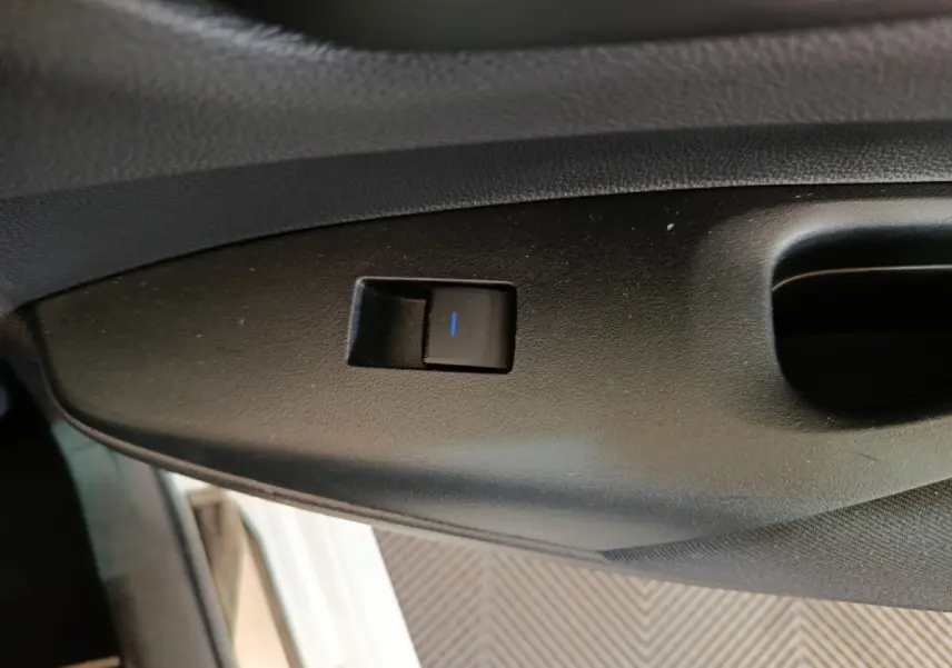 Gros plan sur le bouton de réglage électrique du siège côté conducteur dans une Toyota Corolla Hybride blanche de 2020.