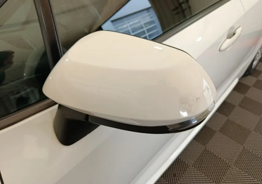 Rétroviseur côté gauche blanc de la Toyota Corolla Hybride 122h Active 2020, vue rapprochée en intérieur.