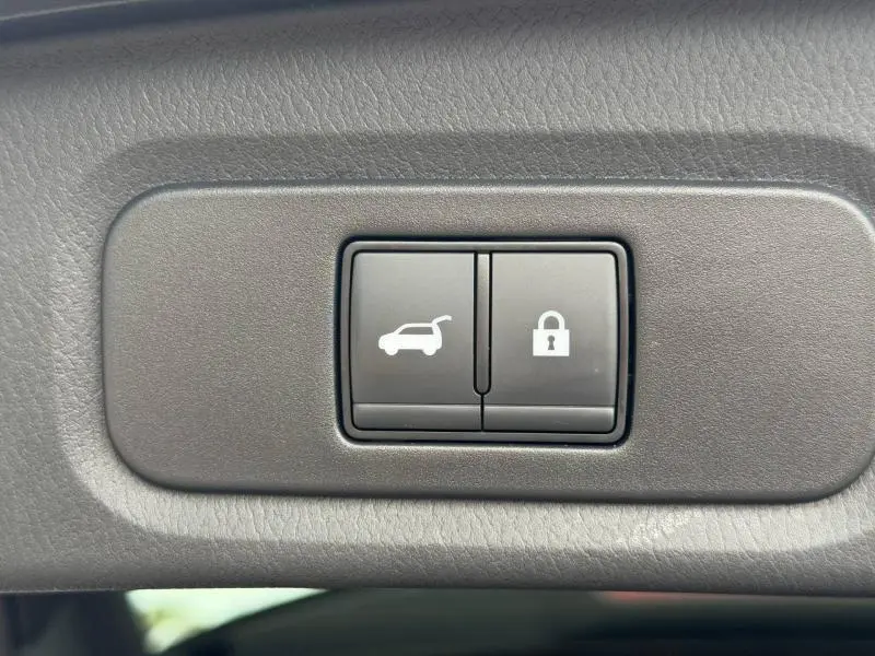 Boutons de commande du coffre et de verrouillage intégrés dans le panneau intérieur gris du Nissan Qashqai 2024 noir Kuro.