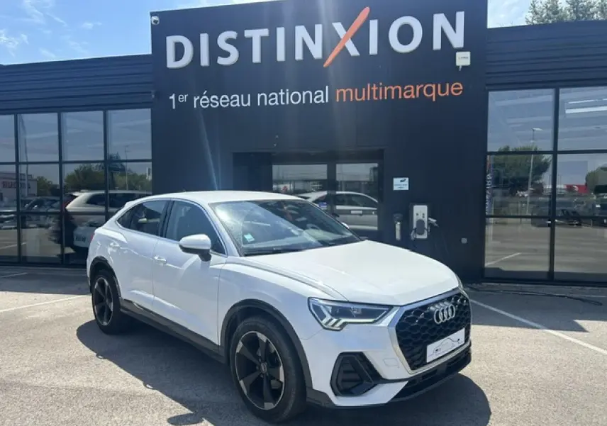 Audi Q3 Sportback blanc en 3/4 avant droit, avec calandre noire et jantes noires à 5 branches doubles.