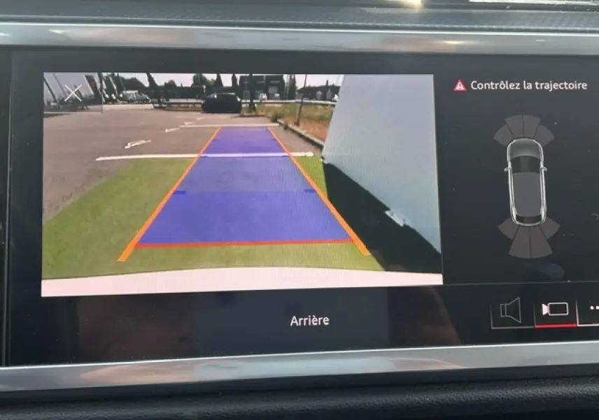 Vue de l'écran de caméra de recul de l'Audi Q3 blanc, affichant les lignes de guidage et l'alerte de trajectoire.