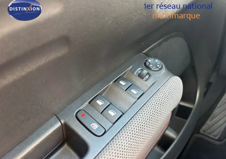 Gros plan sur les commandes des vitres électriques et rétroviseurs côté conducteur d'une Citroën C3 Aircross noir perla metal.