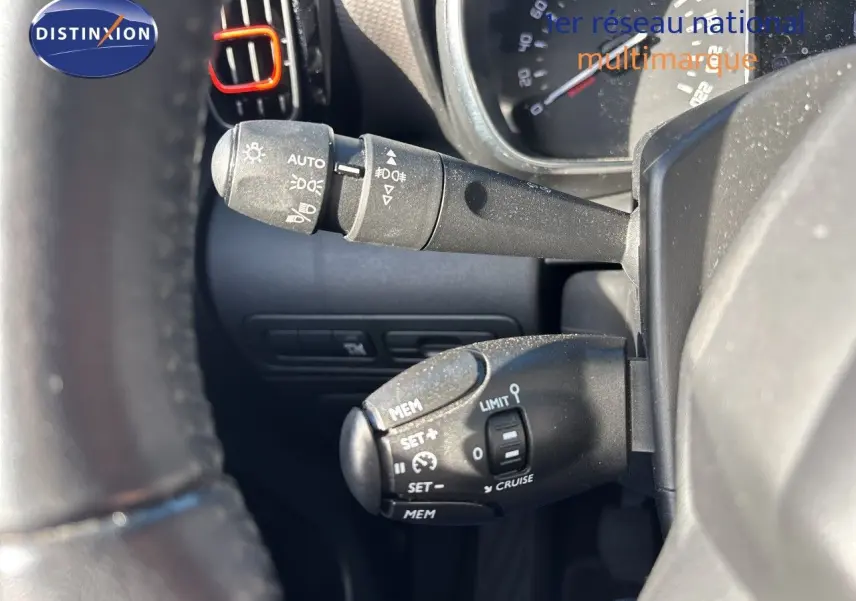 Gros plan sur les commandes au volant du Citroën C3 Aircross noir, mettant en valeur les fonctions de régulateur et limiteur de vitesse.