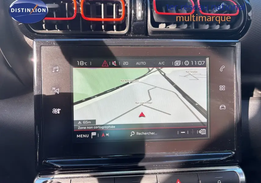 Vue rapprochée de l’écran tactile central avec navigation et aérateurs noirs et rouges du tableau de bord d’une Citroën C3 Aircross.