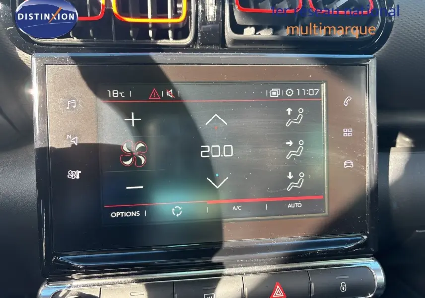 Gros plan sur l’écran tactile central de la Citroën C3 Aircross noir, affichant la climatisation à 20°C avec aérateurs rouges.