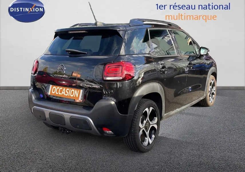 Vue 3/4 arrière droite d'un Citroën C3 Aircross noir Perla Metal avec jantes bi-ton et toit noir.