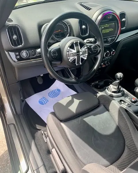 Vue intérieure côté conducteur du MINI Countryman Cooper D 150ch 2017 gris, volant Union Jack et boîte manuelle visible.