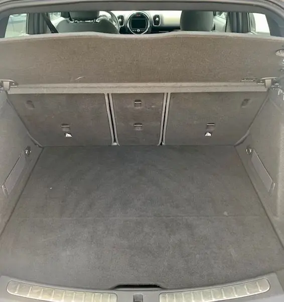 Coffre ouvert vu de l'arrière d'une MINI Countryman Cooper D 150ch gris 2017, montrant l'espace de chargement et l'intérieur.
