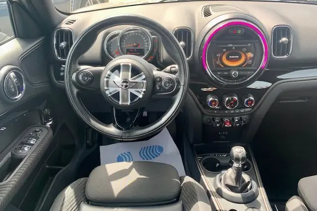 Vue intérieure du tableau de bord et volant du MINI Countryman Cooper D 150ch 2017, avec éclairage circulaire coloré et levier de vitesse manuel.