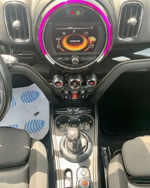 Tableau de bord intérieur de MINI Countryman Cooper D 2017, avec écran multimédia circulaire et éclairage violet autour.