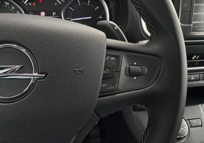 Gros plan sur le volant en cuir noir de l'Opel Zafira Life XL 2024 avec commandes intégrées et tableau de bord partiel.