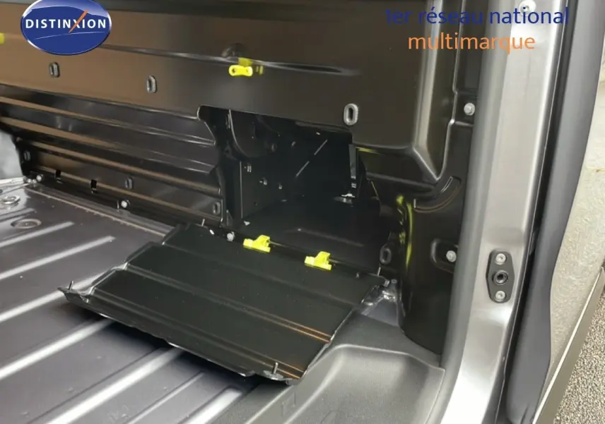 Vue intérieure du coffre du Citroën Jumpy gris Artense, mettant en valeur un compartiment de rangement ouvert sur le côté droit.