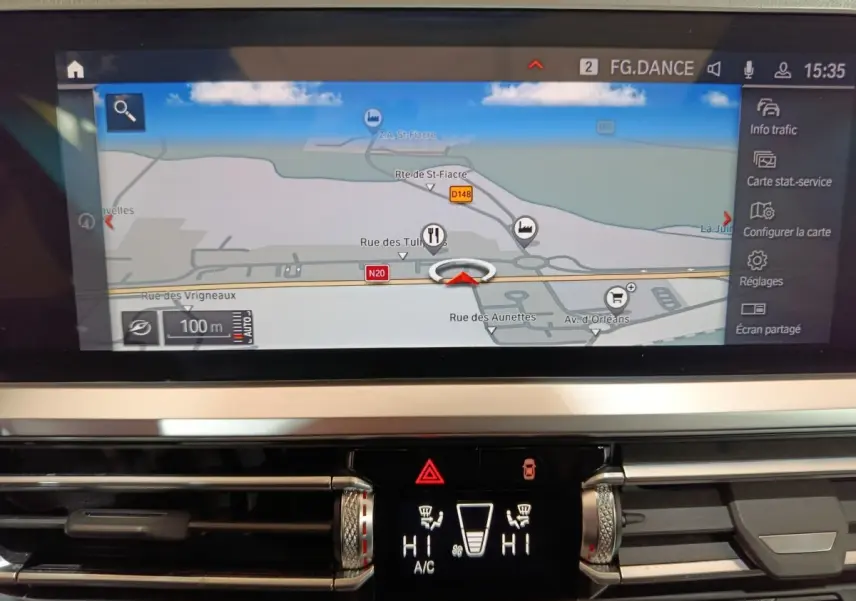 Gros plan sur l’écran tactile central et la console de climatisation d’une BMW Série 3 gris clair, vue intérieure.