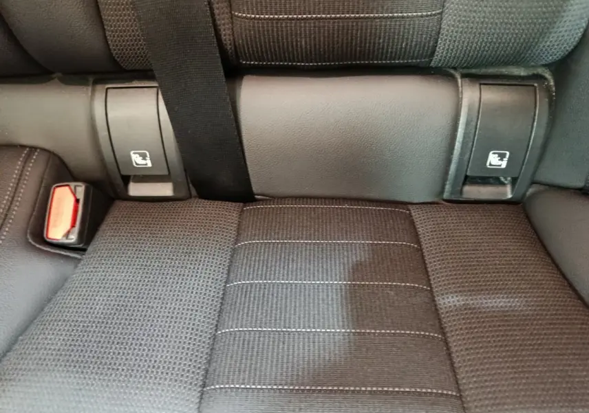 Détail de la banquette arrière noire avec ceintures et fixations Isofix visibles dans une BMW Série 3 318d Lounge.