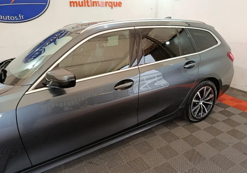 Vue de profil côté gauche d'une BMW Série 3 Touring gris clair avec jantes alliage et vitres teintées.