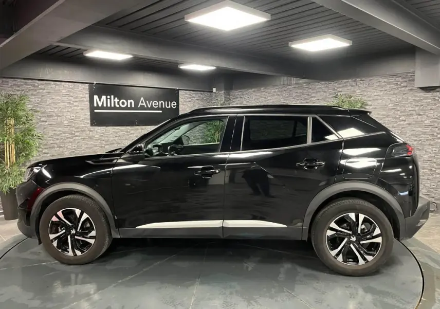 Peugeot 2008 noir perla nacré vue de profil côté gauche, jantes alliage 17'' bi-tons et barres de toit noires.