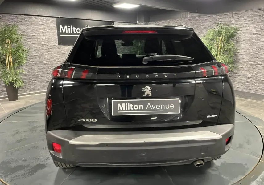 Vue arrière d'un Peugeot 2008 noir Perla Nera avec feux arrière à LED en forme de griffes et becquet couleur carrosserie.