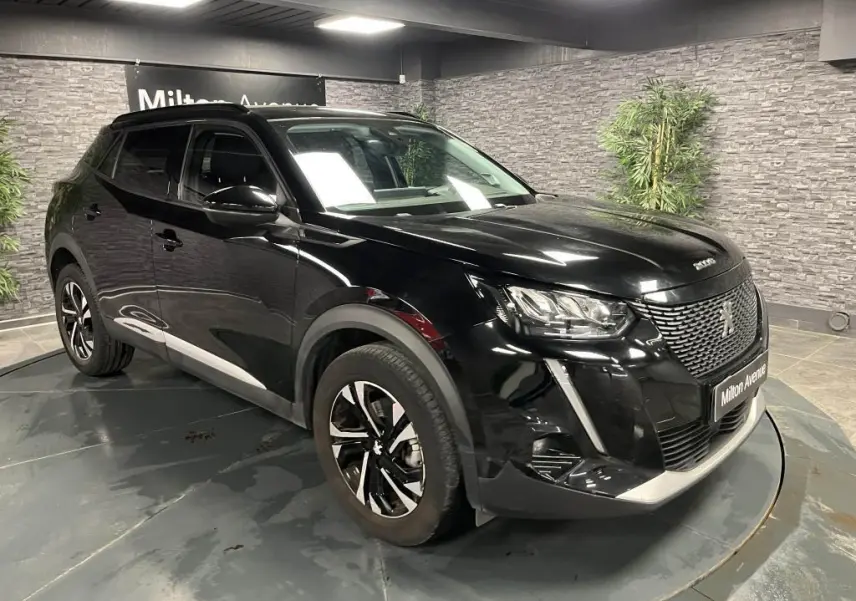 Peugeot 2008 noir perla nacré vue 3/4 avant droit en intérieur avec jantes alliage bi-ton et calandre chromée.