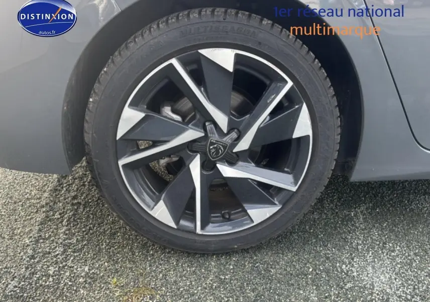 Gros plan sur la jante alu noire et argentée du côté arrière droit d'une Peugeot 308 gris sélénite.