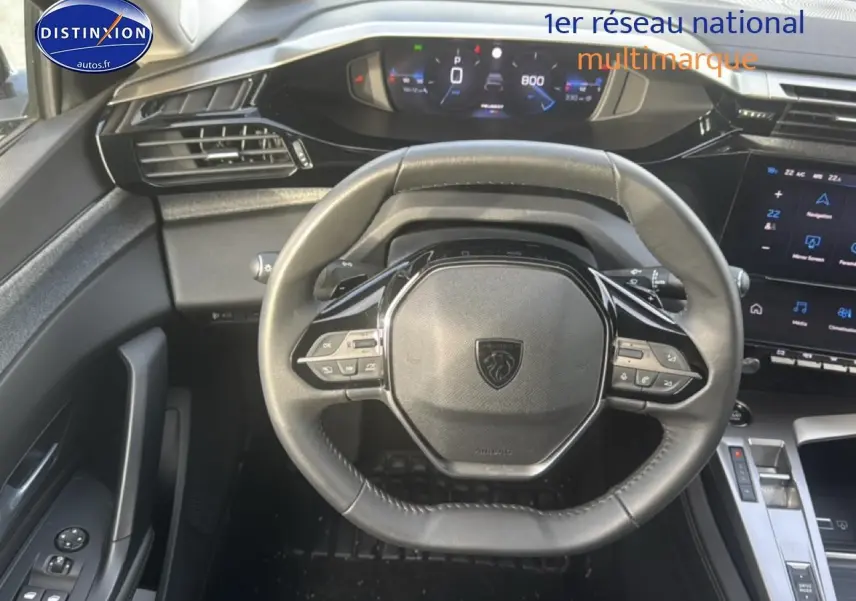 Vue intérieure centrée sur le volant multifonction noir de la Peugeot 308 1.2 130 allure eat8 gris sellenium avec tableau de bord digital.