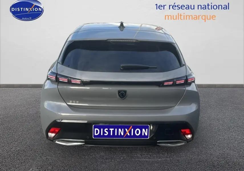 Vue arrière d'une Peugeot 308 gris sélénite 2024 avec feux arrière LED et double sortie d'échappement chromée.