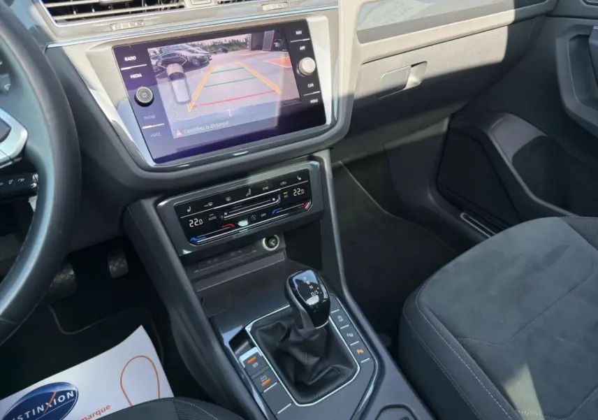 Vue intérieure du Volkswagen Tiguan 2022 noir, console centrale avec écran tactile et levier de boîte automatique DSG7.