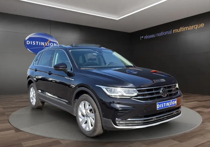 Volkswagen Tiguan noir en 3/4 avant droit, avec jantes argentées et toit ouvrant électrique visible.