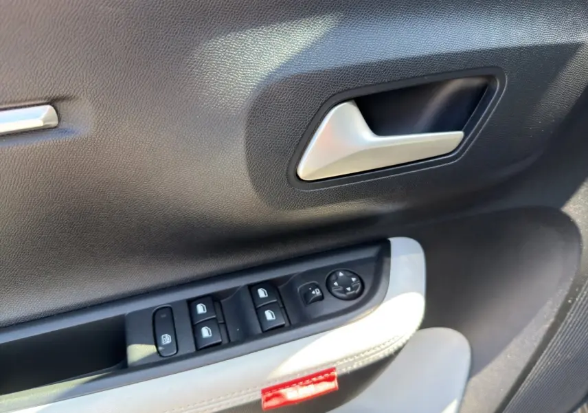 Détail de la porte côté conducteur de la Citroën C3 2025, avec commandes électriques et garniture bi-ton gris foncé et clair.