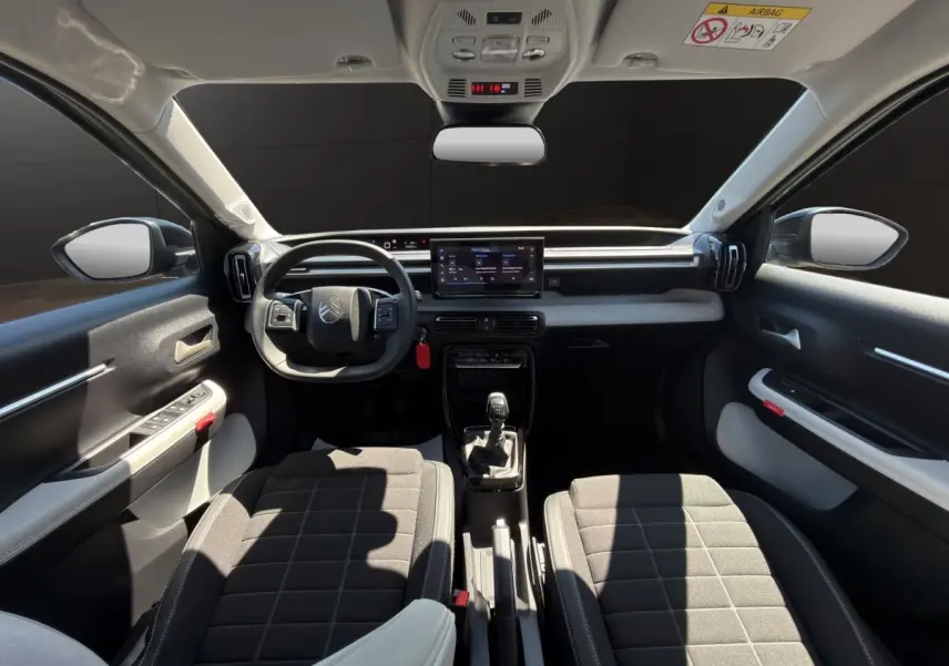 Vue intérieure avant de la Citroën C3 2025, tableau de bord avec écran tactile 10,25 pouces et volant cuir multifonctions.