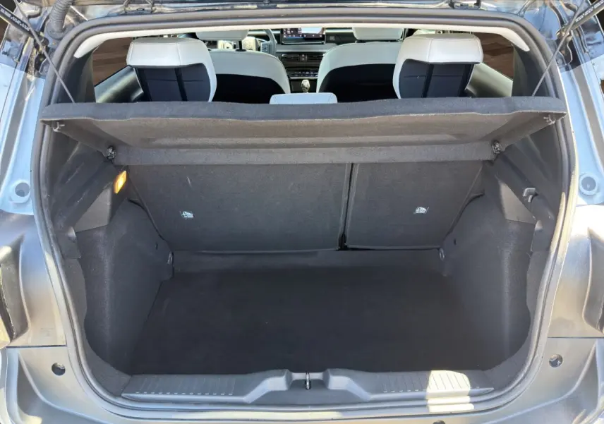 Coffre ouvert vu de l'arrière d'une Citroën C3 gris foncé, intérieur noir avec banquette arrière visible.