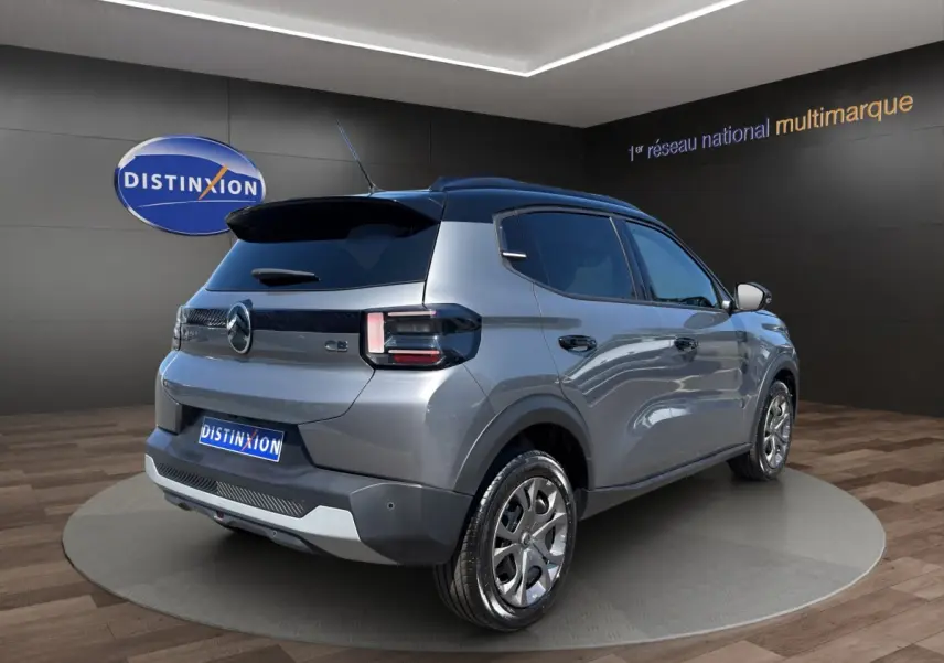 Vue 3/4 arrière droite d'une Citroën C3 2025 gris foncé bi-ton avec toit noir et jantes alliage distinctives.