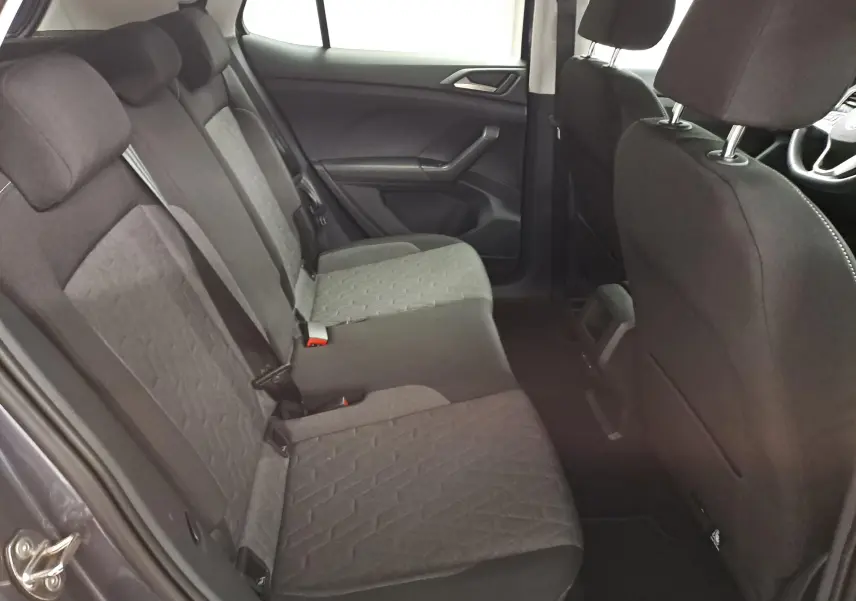 Vue intérieure côté arrière droit du Volkswagen T-Cross 2025, sièges tissu gris avec motifs géométriques.