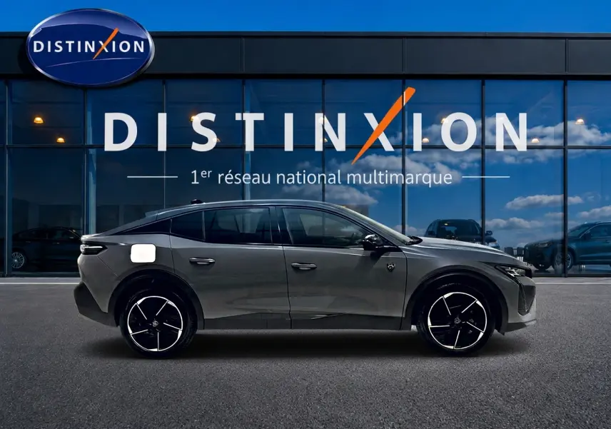 Peugeot 408 Hybrid 145 GT e-dcs6 gris sélénite vue de profil côté gauche devant une vitrine Distinxion.
