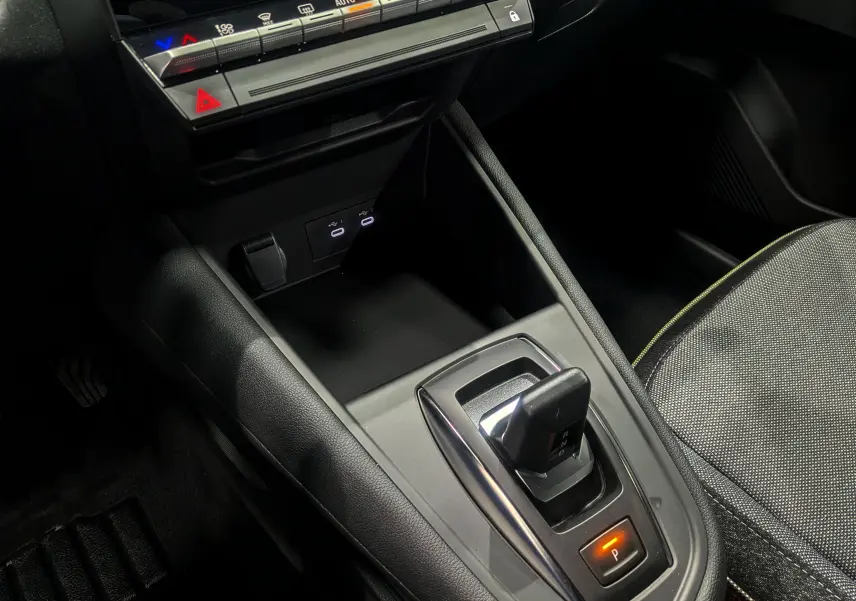 Gros plan sur la console centrale du Renault Captur 2025, montrant le levier de vitesse automatique et les ports USB éclairés.