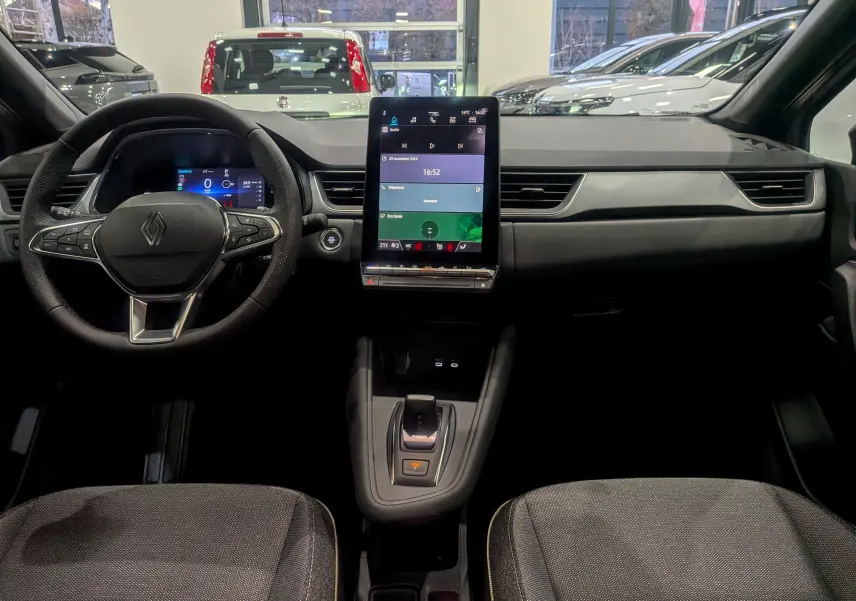 Intérieur du Renault Captur 2025, vue frontale du tableau de bord avec écran tactile vertical et volant multifonction.