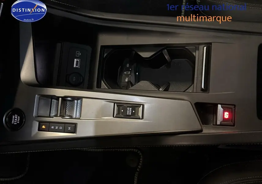 Vue rapprochée de la console centrale grise du Peugeot 408 Hybrid 145 GT avec levier de vitesses automatique et bouton start/stop.