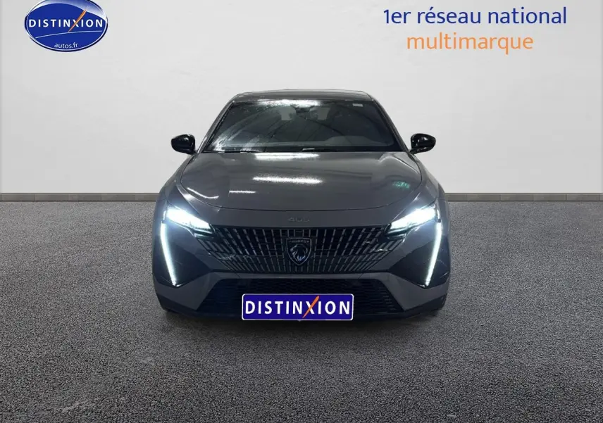 Vue frontale d'une Peugeot 408 Hybrid 145 GT gris sélénite avec phares LED allumés sur fond neutre.