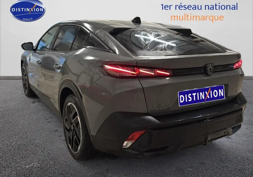 Vue 3/4 arrière droite d'une Peugeot 408 Hybrid 145 GT gris sélénite avec feux arrière LED allumés et jantes alu noires.