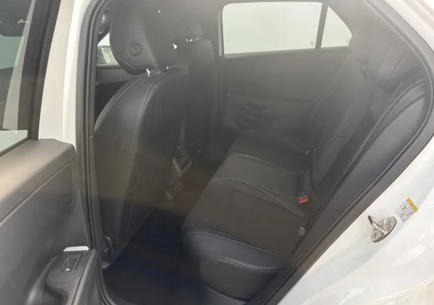 Vue intérieure côté gauche de la banquette arrière en tissu et cuir noir du Volkswagen T-Roc blanc toit noir 2026.