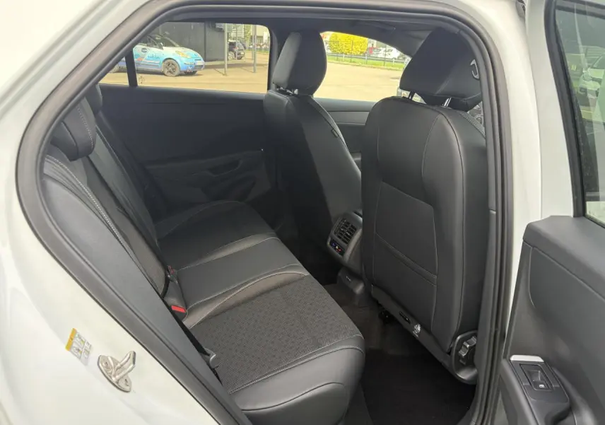 Vue intérieure côté gauche sur la banquette arrière en tissu et cuir noir du Volkswagen T-Roc blanc toit noir 2026.