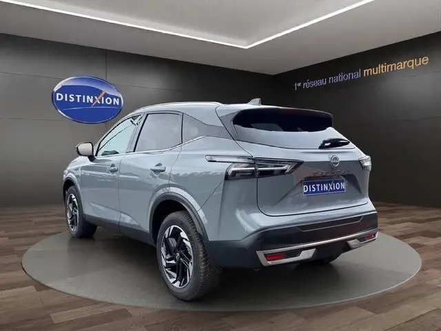 Vue 3/4 arrière droite du Nissan Qashqai gris foncé 2025 avec feux arrière LED et jantes noires distinctives.