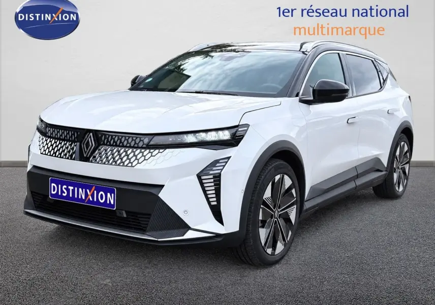 Renault Scenic 5 électrique blanc en vue 3/4 avant droit, avec calandre moderne et jantes stylisées.