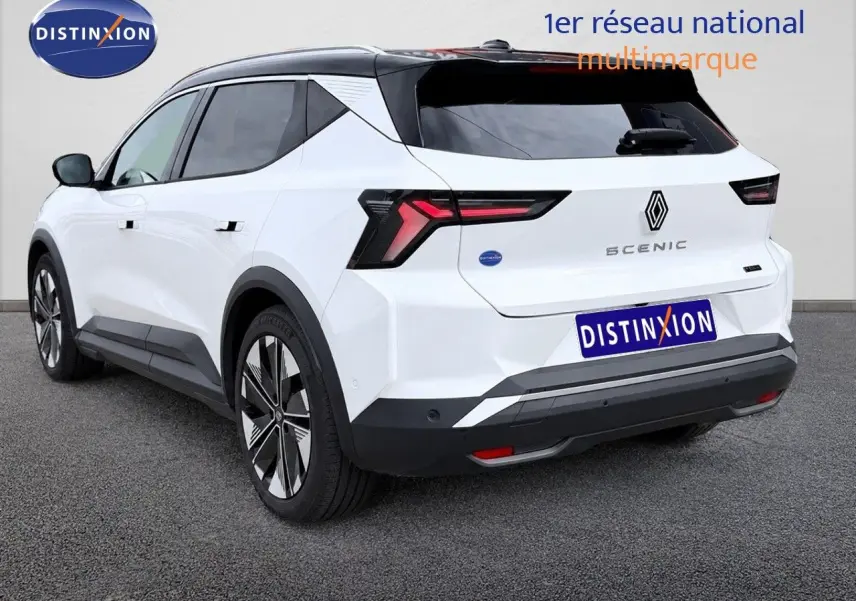 Vue 3/4 arrière droite du Renault Scénic 5 blanc 2024 électrique avec toit noir et feux arrière LED distinctifs.