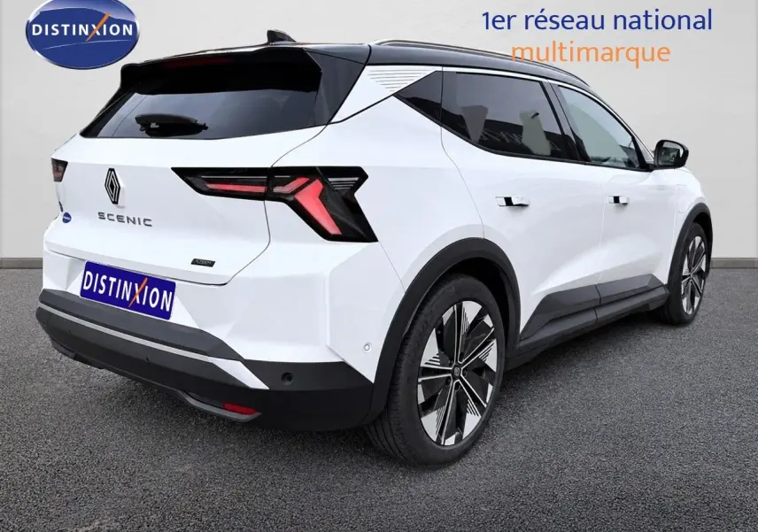 Vue 3/4 arrière droite du Renault Scénic 5 blanc électrique 2024 avec feux arrière en forme de flèche et jantes stylisées.