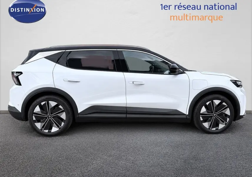 Profil droit du Renault Scenic 5 blanc 2024 électrique avec toit noir et jantes noires à motifs géométriques.